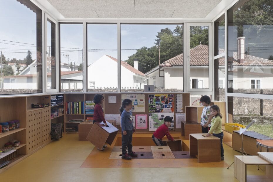 Alumnado jugando cubos de madera que se encajan en el foso.