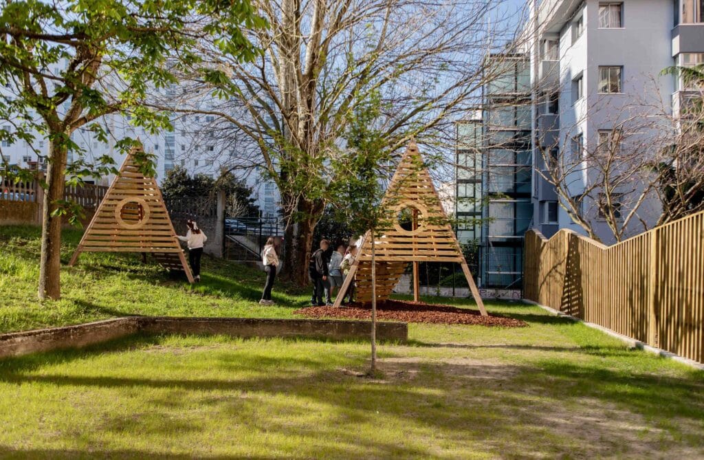 Niños jugando en tipi de madera.