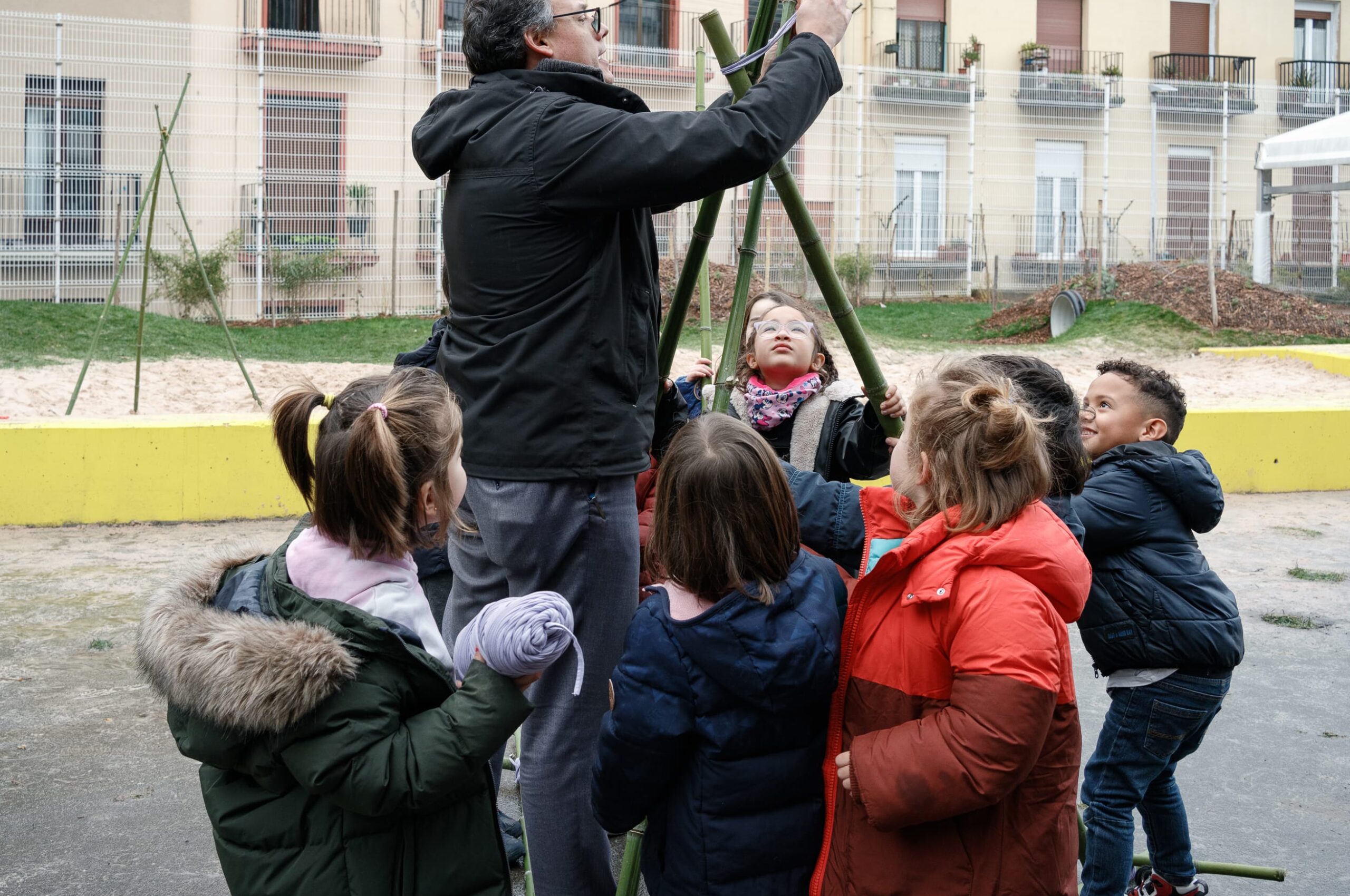 Fermín realizando un taller rodeado de niños en el patio.